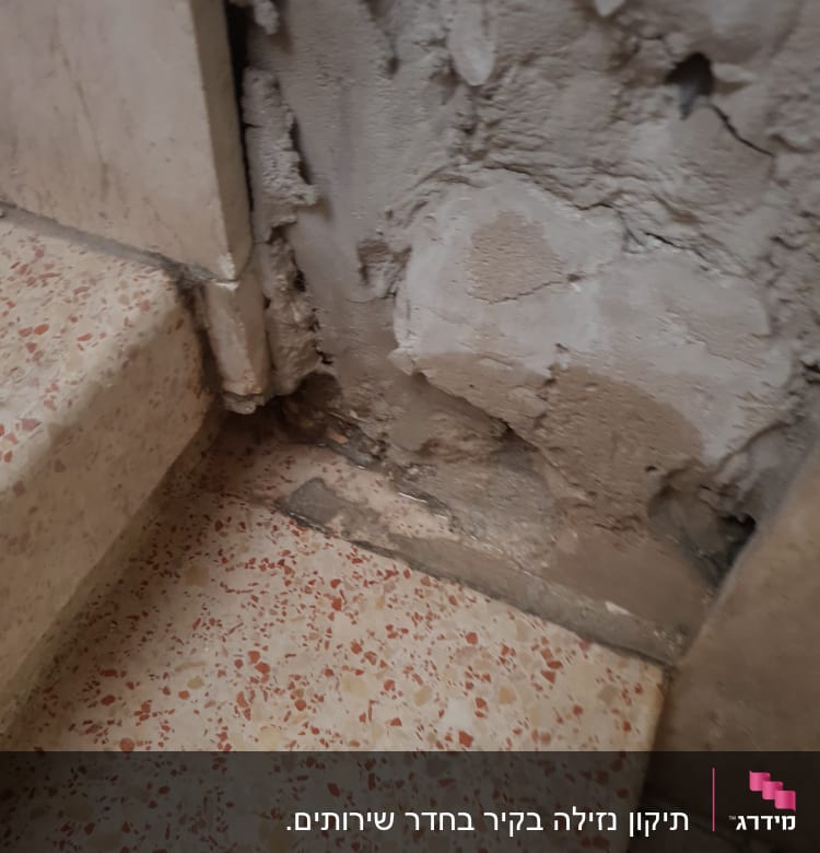 קיר עם טיח מתקלף ליד רצפה